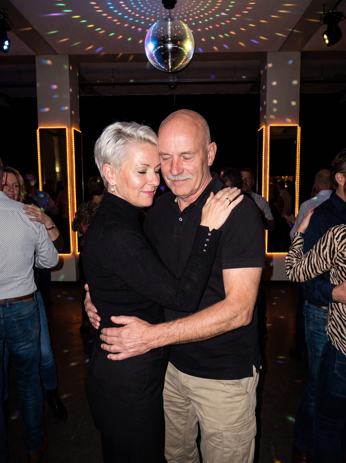 Mireille and Henk-Jan slow dancing under a disco ball.